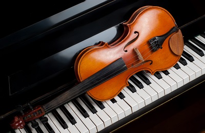 violin sitting on top of piano keys